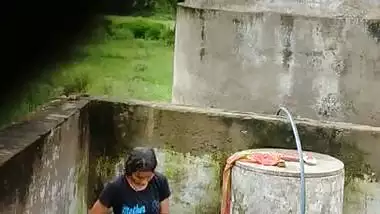 Indian village girl bathing near water tank outdoor